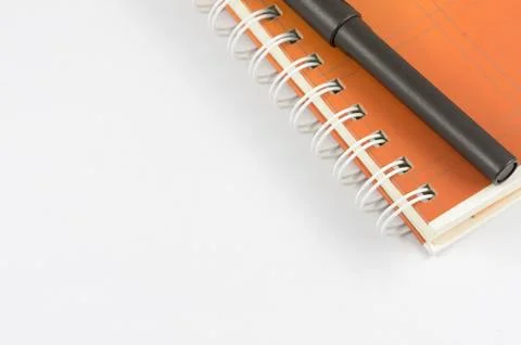 Orange note book and black pen 스톡 사진