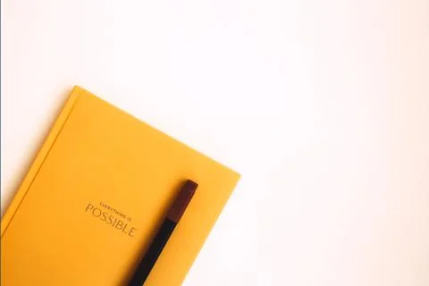Orange notepad and brown marker on light background Stock Photos