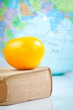 Orange on old book Stock Photos