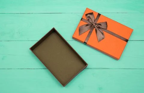 Orange opened gift box on a turquoise wooden background 스톡 사진