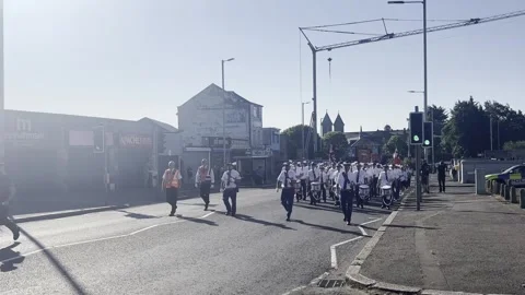 An Orange Order July 12 parade completes its return route past a former flashpo Video stock 339614290