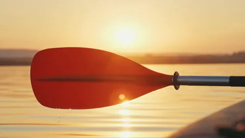 Orange paddle on kayak rowing drop of water dripping slowly onto calm surface Stock Footage 141423350