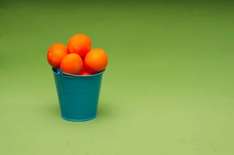 Orange painted easter eggs in small bucket. Minimalistic composition. Place f Stock Photos