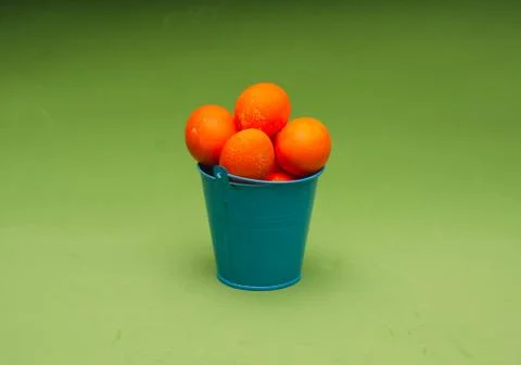 Orange painted easter eggs in small bucket in the center of the frame. Minima Stock Photos