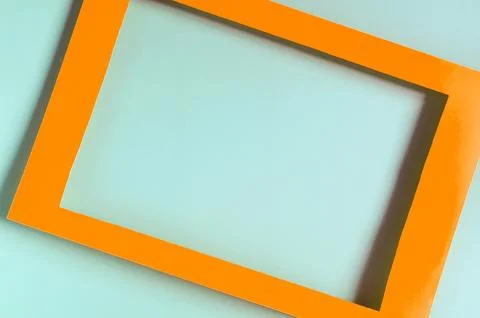 Orange paper frame on a colored background. Stock Photos