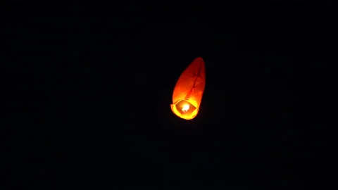An orange paper lantern flies in total darkness Stock Footage 131425504
