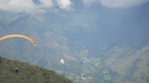 Orange Paraglider Flying on a Cloudy Day near the City of Medellin Stock Footage 165565320