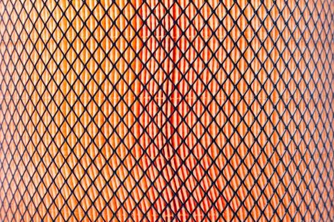 Orange pattern of porous material covered by black mesh. Truck air filter clo Photos