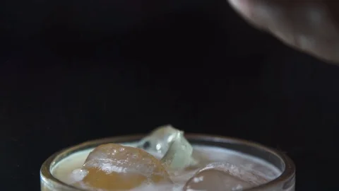 Orange peel being squeezed on drink by hand Stock Footage 90123574