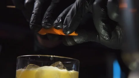 Orange peel being squeezed on drink Stock Footage 90123575