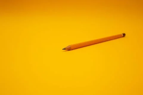 Orange pencil on a bright background Stock Photos