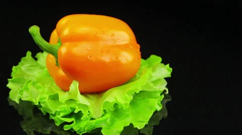 Orange pepper lies on a salad leaf and spinning Stock-Footage 39719786