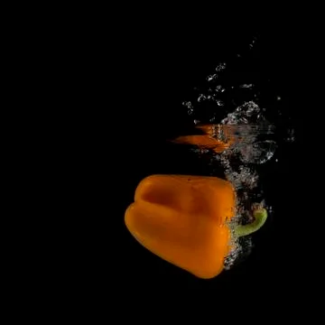 Orange pepper splashed into water 写真素材