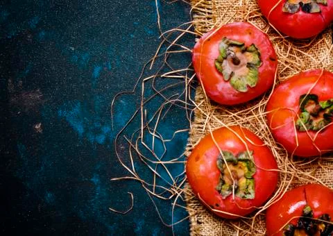 Orange Persimmons On Black Background, Rustic Style, Top View Stock Photos