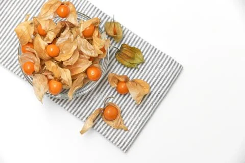 Orange physalis berries on stripped kitchen napkin isolated on white background Stock Photos