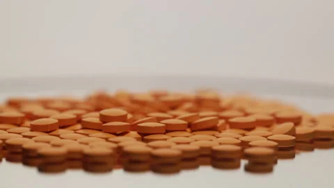 Orange pills on the turntable Stock Footage 249973050