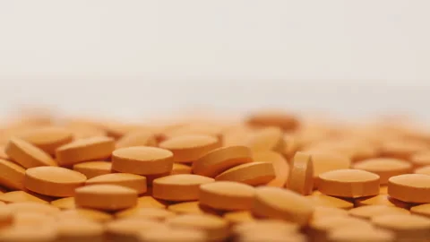 Orange pills on the turntable Stock Footage 249973160