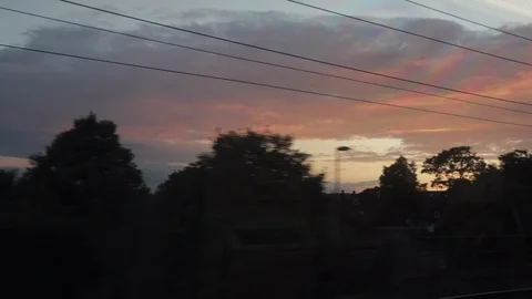 Orange pink sunset viewed from train. Golden hour, dusk North London UK. Video stock 95239663