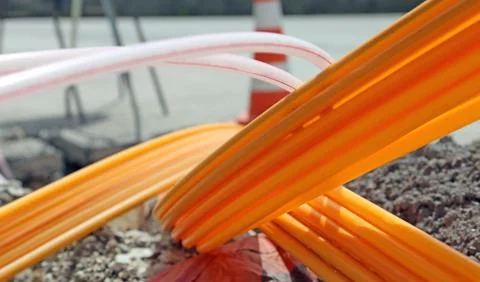 Orange pipes for fiber optics in a large city road construction Stock Photos