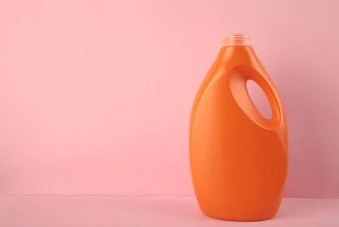 Orange plastic bottle with liquid laundry detergent or cleaning agent or bl.. Stock Photos