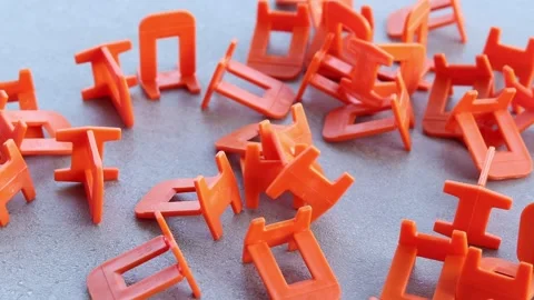 Orange plastic clamps for tile leveling system, close-up Stock Footage 340568739