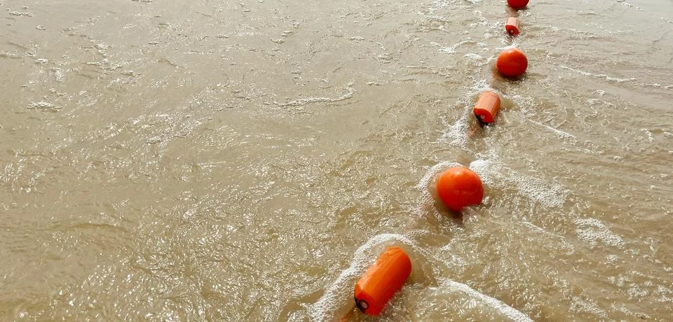 Orange plastic float washed up on the sandy shore. Earth Day. World Maritim.. Stock Photos
