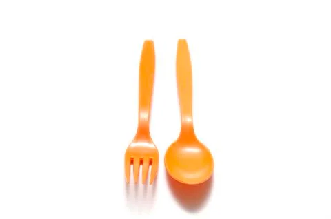 Orange plastic spoon and fork Stock Photos
