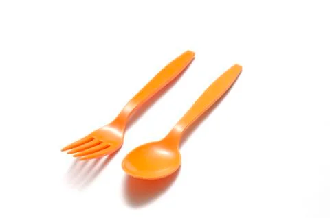 Orange plastic spoon and fork Stock Photos