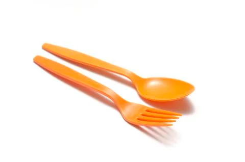 Orange plastic spoon and fork Stock Photos