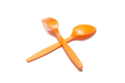 Orange plastic spoon and fork Stock Photos