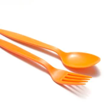 Orange plastic spoon and fork Stock Photos