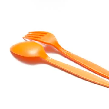 Orange plastic spoon and fork Stock Photos