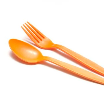 Orange plastic spoon and fork Stock Photos