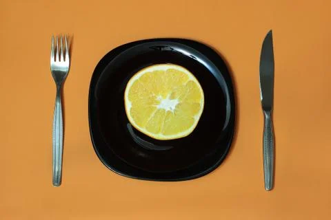 Orange, plate, fork, knife Stock Photos