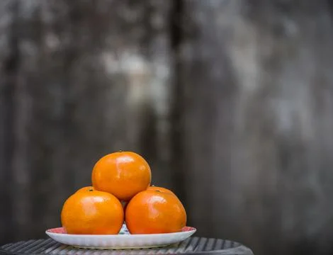 Orange in plate with gray background. Stockfoto's