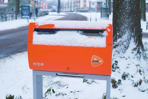 Orange postbox in snow Stock Photos