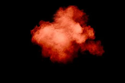 Orange powder dust particles explosion on black background.Orange dust part.. Stock Photos