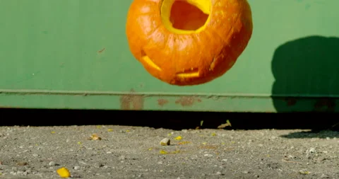 Orange pumpkin falling into the ground and scattering into pieces Stock Footage 145054459