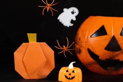 Orange pumpkins, a ghost, spiders and spider webs on a black background, a .. Stock Photos