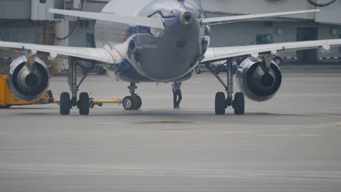 Orange pushback tug push backwords an Airbus A320 in Sheremetyevo airport Stock Footage 94513765
