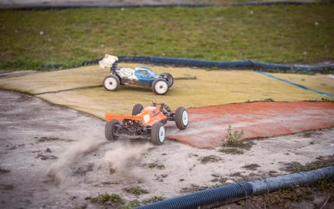 Orange RC buggy accelerating from a corner on an outdoor track Stock Photos