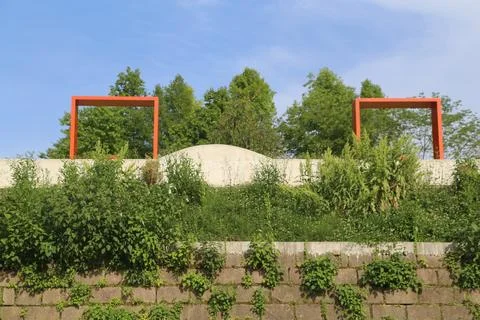 Orange rectangular frames above a vine-covered stone wall and green hillsid.. Stock-Fotos