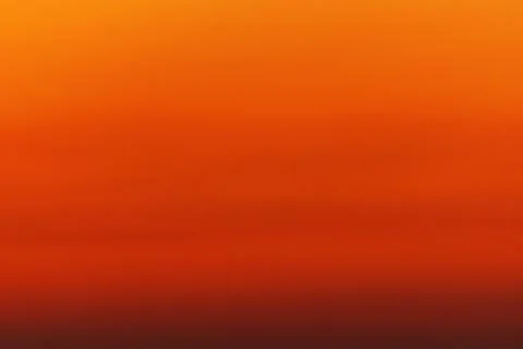 Orange red defocus shot of gradient sky at sunset over ocean horizon. The c.. Stock Photos