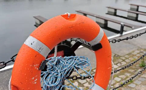 Orange rescue ring with launch roupe on a pier Stock Photos