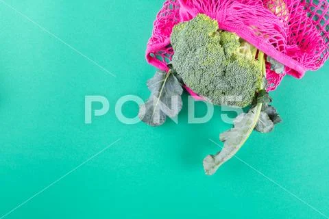 Orange reusable mesh bag with produce on green Stock Photos