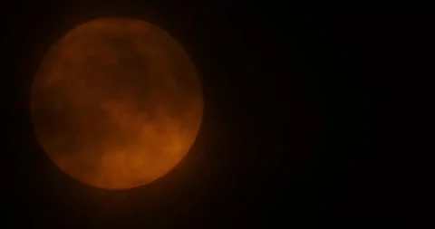 Orange rising moon by the bourgeois plan. The moon passes slowly through the clo Video stock 168182113