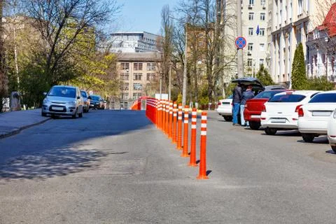 Orange road columns bisect the carriageway in spring sunny day. Stock Photos