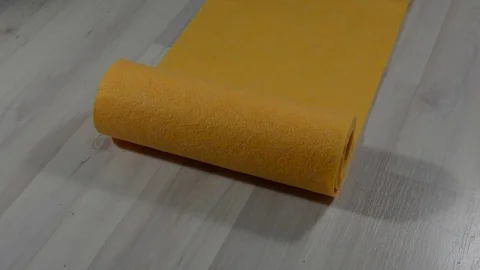 Orange roll of paper towels rolls out on a bright floor 스톡 동영상 123714234