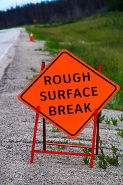 An orange rough surface break sign with construction pylons behind it Stock Photos