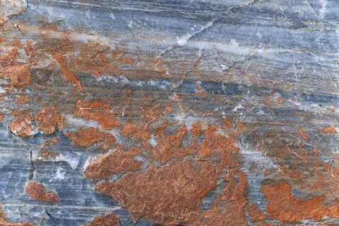 Orange rust coating on gray surface of stone. Texture. Stock Photos